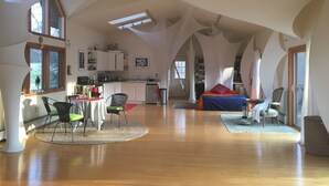 Um interior espaçoso com pé direito alto, área de jantar, cozinha e quarto.