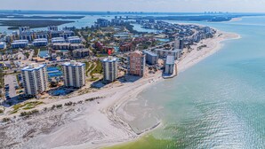 Eine Küstenstadt mit Hochhäusern, einem Sandstrand und einer Marina.
