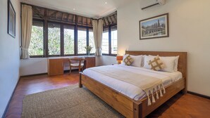 Un dormitorio con cama de madera, un escritorio, una silla y una ventana con cortinas.