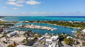 A marina with boats, a sandy beach, and buildings. - 1 BD,1.5 Bathroom, Beautiful Condo (Providenciales)