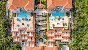 An aerial view of a resort with two swimming pools, sun loungers, and a central circular fountain. - 1 BD,1.5 Bathroom, Beautiful Condo (Providenciales)