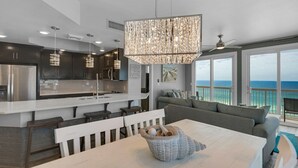 A modern kitchen with a central island, dark cabinetry, and pendant lighting.