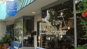 A storefront with a sign reading "The Dairy Godmother" and a blue bench outside. - Del Ray Designer Home walk to Shops, Cafes, Fun (Alexandria)