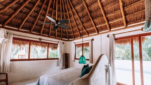 A bedroom with a bed, a ceiling fan, and large windows with curtains. - Zorba Villa 3, Stunning 3BR Villa with private rooftop patio! Sleeps 8. (Tulum)