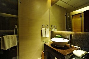 A modern bathroom with a large mirror, a bowl sink, and a glass shower enclosure. - King Sa Hotel (Shishi)