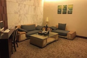 A modern living room with a sofa, coffee table, and a TV. - King Sa Hotel (Shishi)