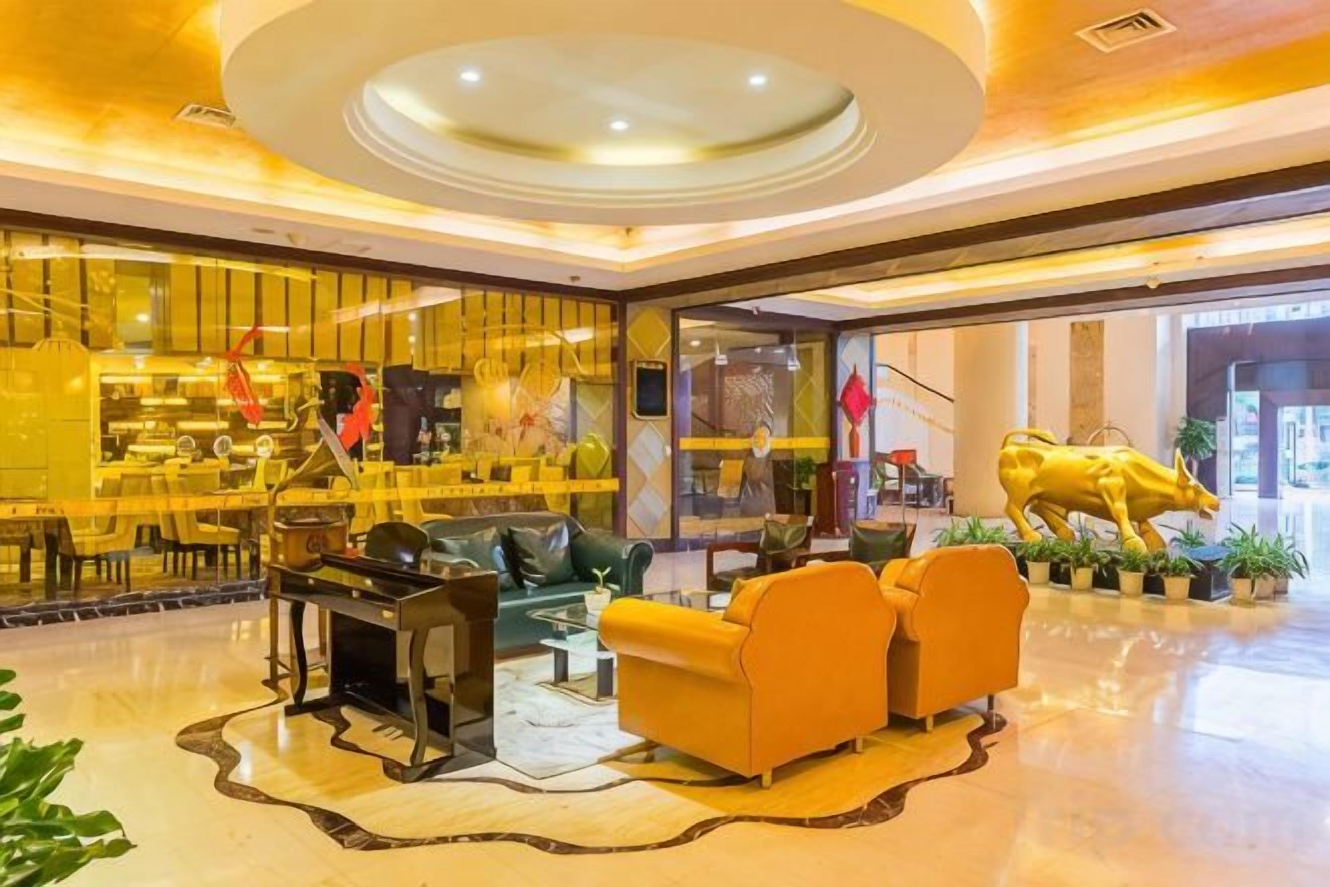 A lobby with a seating area, a bar, and a large golden statue.
