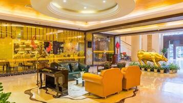 A lobby with a seating area, a bar, and a large golden statue.