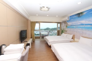A hotel room with two beds, a TV, a desk, and a view of the sea. - HF Keelung 61 (Keelung)