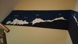 A staircase with a night sky mural featuring mountain silhouettes and star patterns.