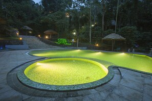 Una piscina al aire libre, sombrillas, sillones reclinables de piscina