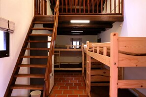 A staircase leading to a bunk bed room with a brick floor and wooden railings. - Blue mountain inn (Jinning)