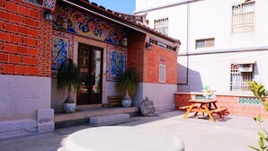 A courtyard with a stone bench, potted plants, and a wooden table. - Blue mountain inn (Jinning)