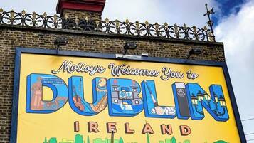 A large billboard with "Molly's Welcomes You to Dublin Ireland" and a cityscape illustration.