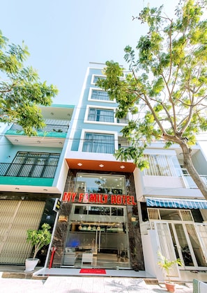 Welcome to MY FAMILY HOTEL, a modern building with a prominent entrance and lobby view.