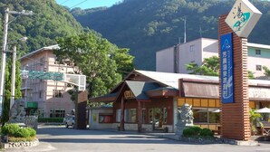 Un hotel con vista a la montaña, fachada de madera y un cartel que indica que se trata de un hotel.