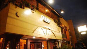 A building with a crescent moon design on the facade, a sign reading "CENTRO", and a street lamp above.