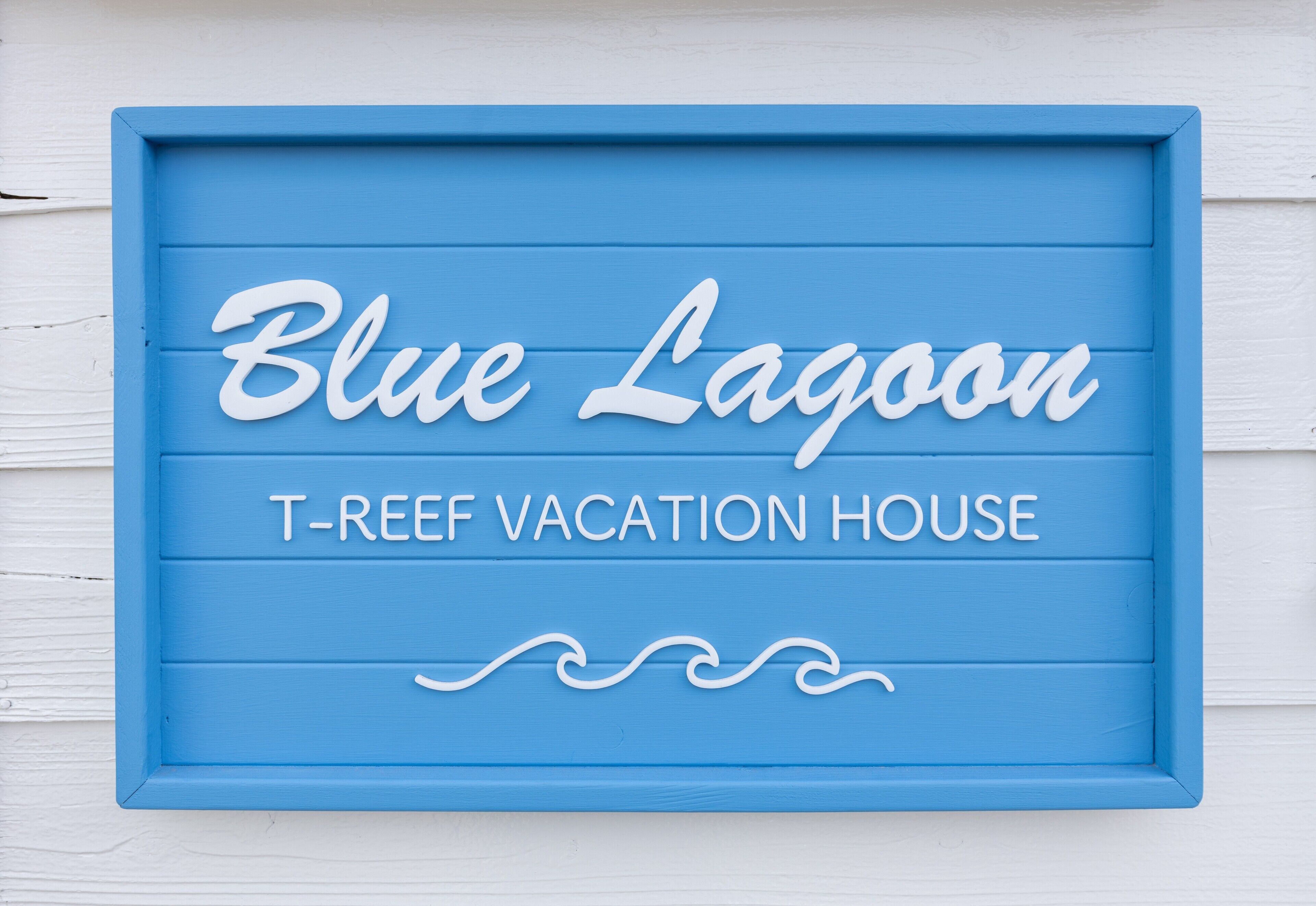 A blue sign with the text "Blue Lagoon T-Reef Vacation House".