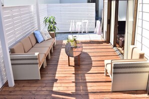 A wooden deck with a sofa, chairs, and a table. - Blue Lagoon (Kamakura)