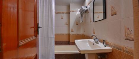 A bathroom with a sink, mirror, and shower curtain.