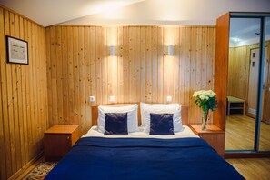 Cozy retreat with a comfortable bed, bedside tables, and a mirror.