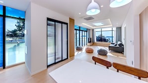 Een modern interieur met een eethoek, zitplaatsen en grote ramen.