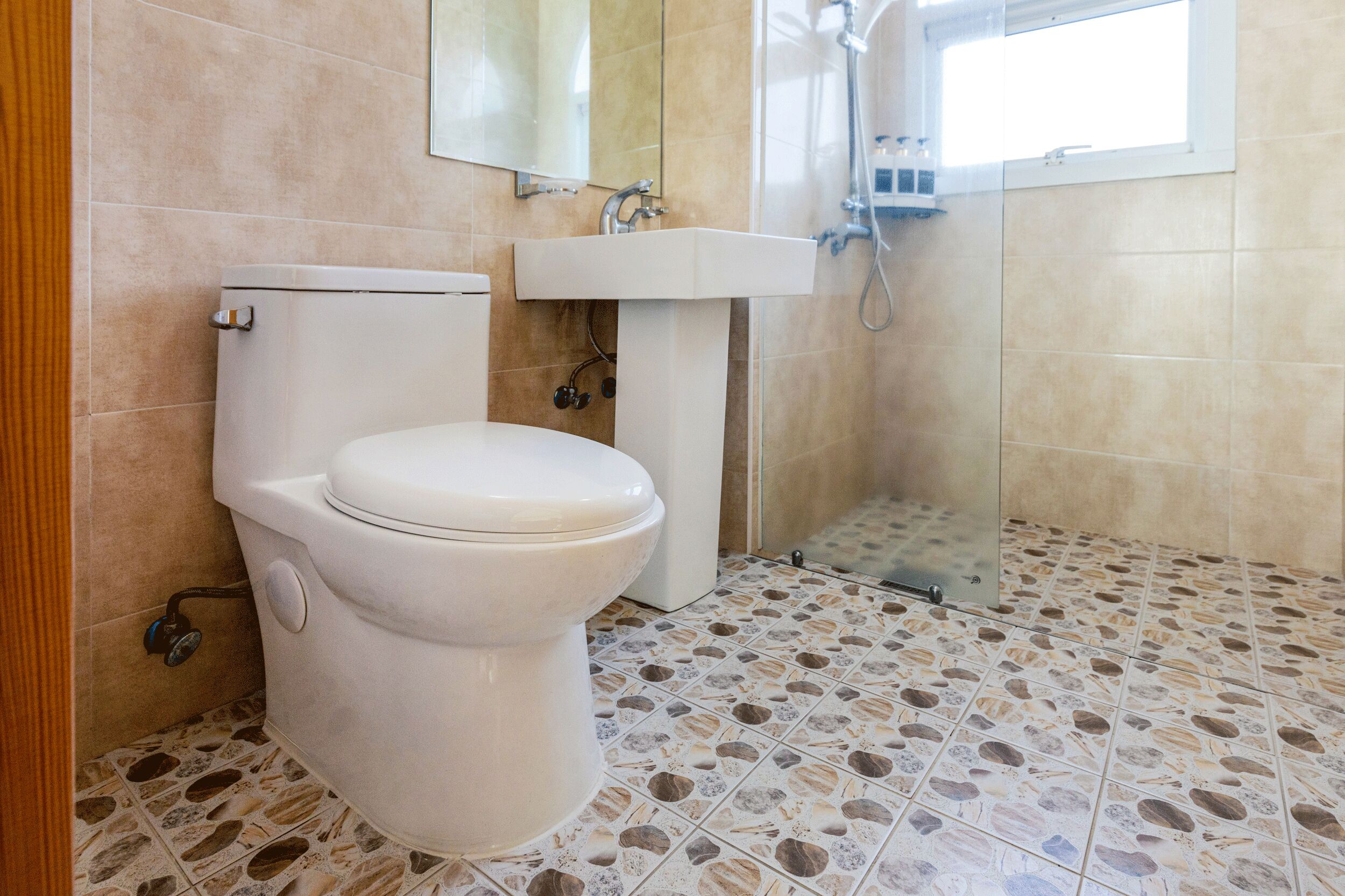 Un baño con inodoro, lavabo y ducha.