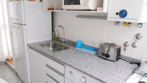 A compact kitchen with a sink, a microwave, a toaster, and a washing machine. - Santa Fe & Carranza By Foreign In Baires (Buenos Aires)