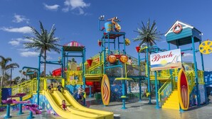 Ein Wasserpark mit Rutschen, einem Rettungsboje und einem Schild mit der Aufschrift 'Beach'.