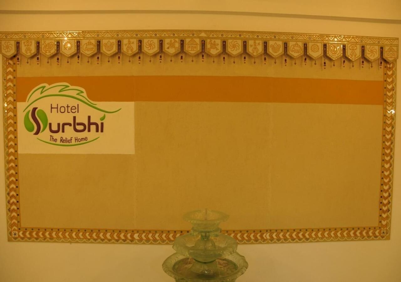 A wall with a decorative border and a sign for Hotel Surbhi, The Relief Home.