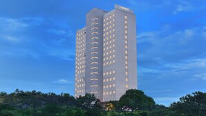 Un hotel alto y moderno con tejado plano y numerosas ventanas.
