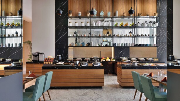Una cocina moderna con encimeras de mármol, armarios de madera y una isla central con asientos.