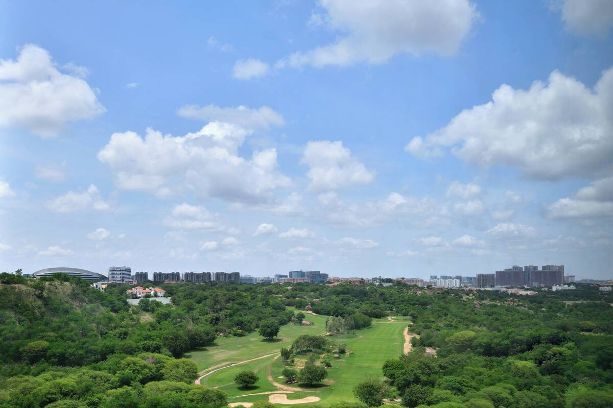 Ein Golfplatz mit einer Stadtkulisse im Hintergrund.