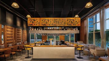 A bar area with a counter, stools, and a variety of bottles.