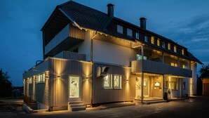 A two-story building with a balcony, a front entrance, and a display window. - Hotel Sonnenhof (Neuweiler)