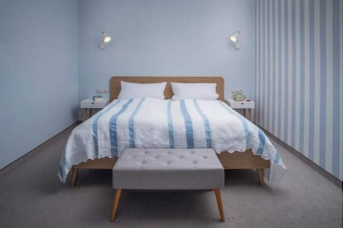 A bedroom with a bed, bedside tables, and a bench.