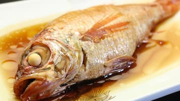 Ein ganzer Fisch auf einem Teller mit Soße.