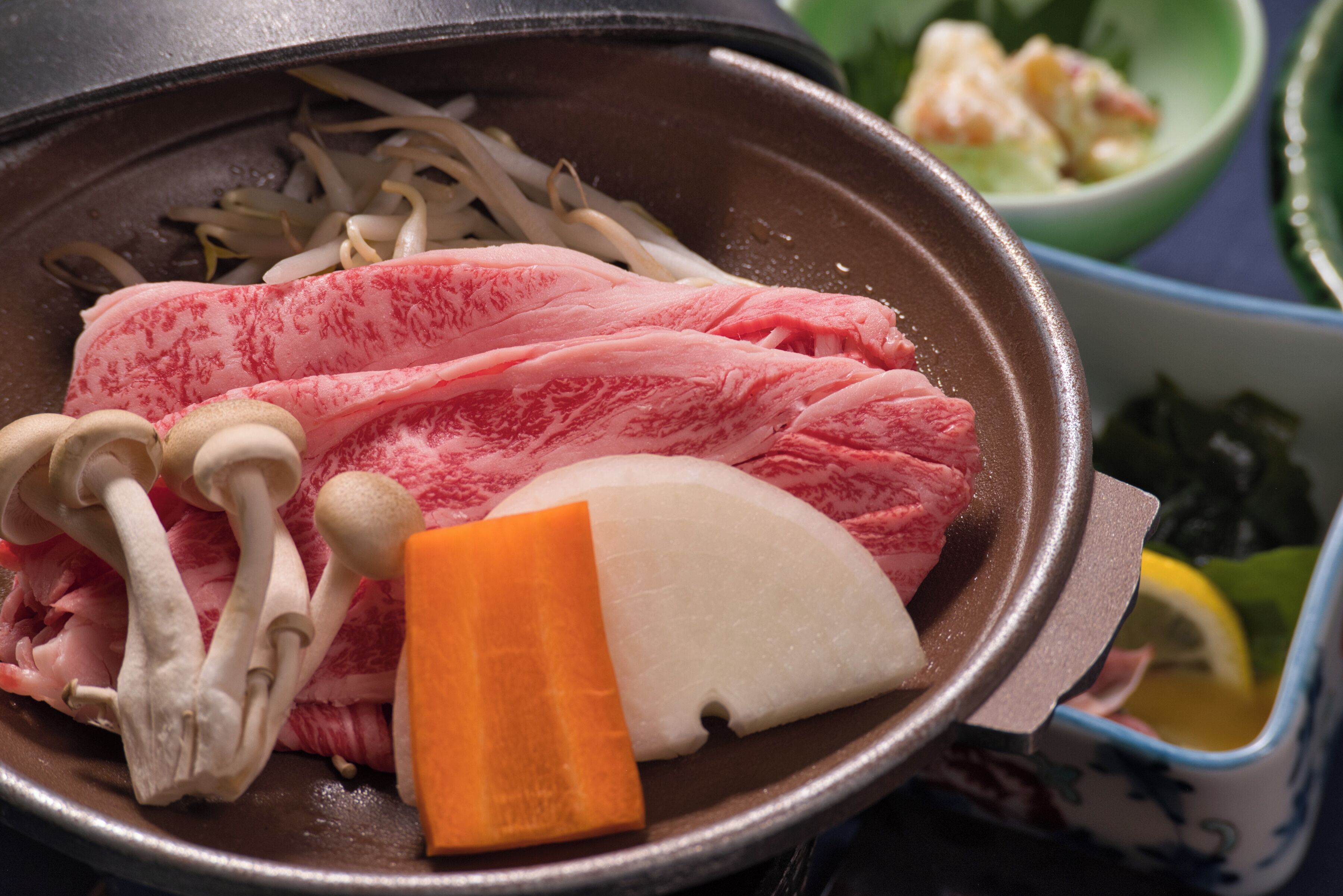 Une fondue où l’on fait cuire divers ingrédients, notamment des champignons, de la viande et des légumes.