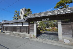 Un bâtiment traditionnel japonais, doté d’un toit recouvert de tuiles et d’une enseigne.
