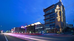Een hotel met modern design, herkenbaar aan een opvallend bord en een goed verlichte gevel.