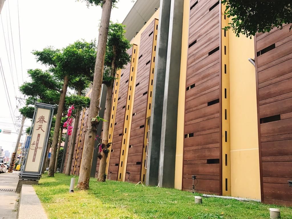 Un bâtiment moderne doté de panneaux de bois verticaux et d’un mur d’accent jaune.
