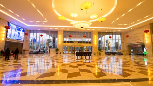 A spacious lobby with a checkered floor, large windows, and a central seating area. - Loudi Huatian Hotel (Loudi)