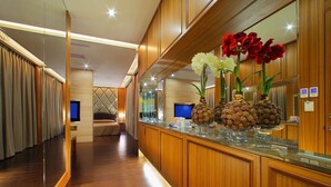A hotel lobby with wooden paneling, a reception desk, and a seating area with a TV. - Spring Hotel (Taichung)