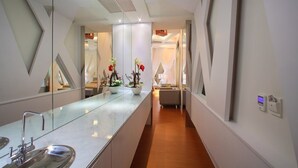 A modern bathroom with a large mirror, a sink, and a potted plant. - Spring Hotel (Taichung)