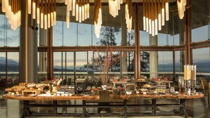 Un dispositiu de menjar a gran bufet amb diversos plats i un espai per al cafè en una habitació àmplia amb grans finestres i il·luminació moderna.
