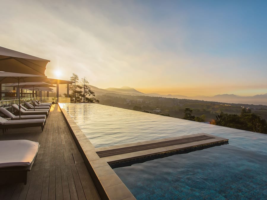 Una piscina al aire libre, sillones reclinables de piscina