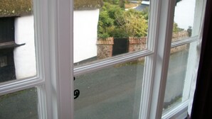 A window with a view of a residential street, houses, and greenery. - Middletown Farmhouse B&B (Okehampton)
