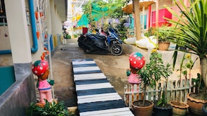 A narrow alleyway with a zebra crossing, potted plants, and a scooter parked in the background. - Aiem Sa Ard Resort (Koh Lan)