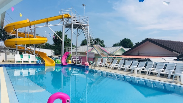 A swimming pool with a water slide and a flamingo float. - Aiem Sa Ard Resort (Koh Lan)