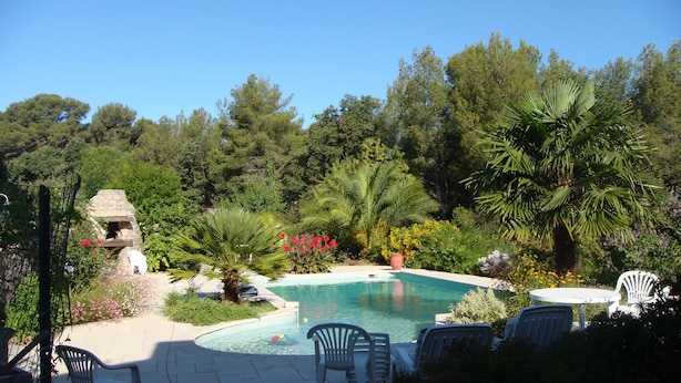 A pool surrounded by lush greenery and a stone structure. - Beautiful ground floor villa with swimming pool, Le Pradet (Var)   (Le Pradet)